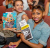 Audience members smile while holding theater programs during a Roundabout Theatre Company community discussion event.